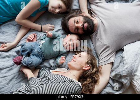 Elevato angolo di visione della famiglia rilassante sul letto Foto Stock