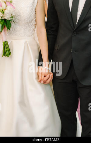 Sposa e lo sposo tenendo le mani Foto Stock