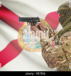 Maschio con la pistola in mano e stato americano bandiera sulla serie di sfondo - Florida Foto Stock