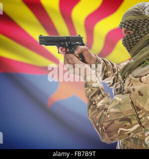 Maschio con la pistola in mano e stato americano bandiera sulla serie di sfondo - Arizona Foto Stock