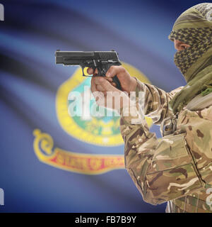Maschio con la pistola in mano e stato americano bandiera sulla serie di sfondo - Idaho Foto Stock