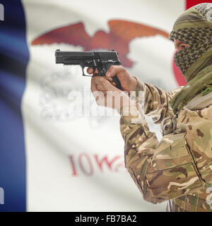 Maschio con la pistola in mano e stato americano bandiera sulla serie di sfondo - Iowa Foto Stock