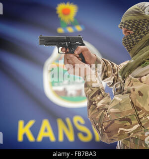 Maschio con la pistola in mano e stato americano bandiera sulla serie di sfondo - Kansas Foto Stock