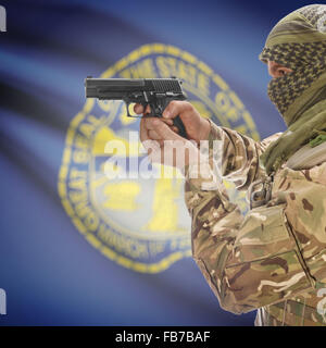 Maschio con la pistola in mano e stato americano bandiera sulla serie di sfondo - Nebraska Foto Stock