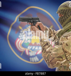 Maschio con la pistola in mano e stato americano bandiera sulla serie di sfondo - Utah Foto Stock