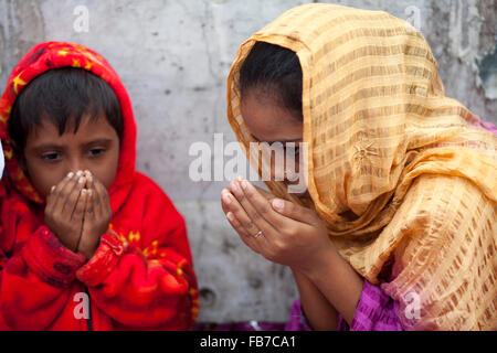 Dacca in Bangladesh 10 Gennaio 2016: bangladese devoti musulmani frequentano il Akheri Munajat preghiere conclusive sul terzo giorno di Biswa Ijtema, la seconda più grande congregazione musulmana dopo l'Hajj, a Tongi stazione ferroviaria in Tongi 20 km da Dacca, il 10 gennaio 2016. Circa due milioni di musulmani dal Bangladesh e all'estero osservato la tre-giorni di Congregazione con la preghiera sulle rive del fiume Turag. Foto Stock