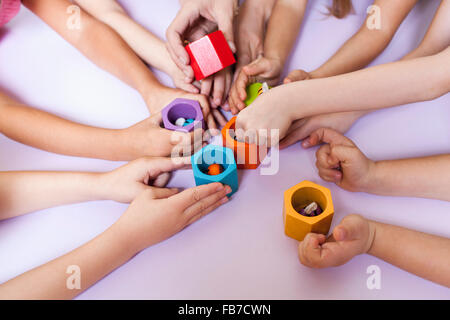 Immagine ritagliata di insegnante con gli studenti a giocare nella scuola elementare Foto Stock