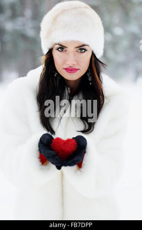 Brunette holding cuore rosso Foto Stock