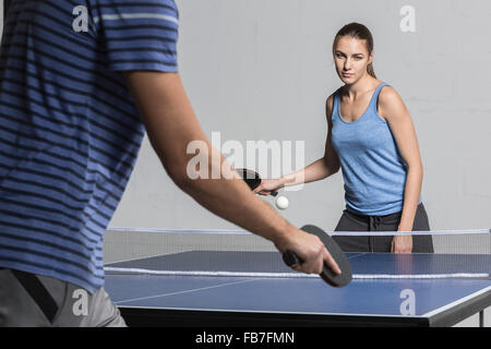 Fiducioso giovane donna giocando a ping-pong con uomo Foto Stock