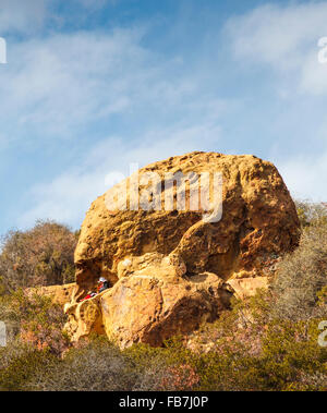 Escursionista si rilassa al cranio Rock off il Temescal Ridge Trail nel Topanga State Park, a cui si accede tramite il Gateway Temescal Park Foto Stock