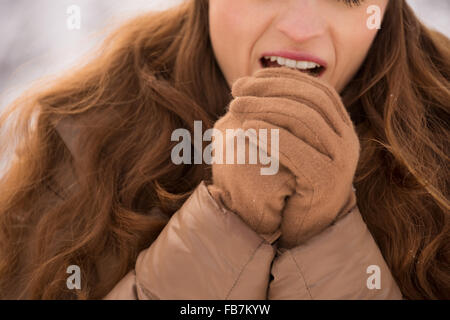 Energy-riempimento e eccitante weekend invernale in montagna. Primo piano sulla donna mani di riscaldamento con respirare all'aperto tra la neve-ca Foto Stock