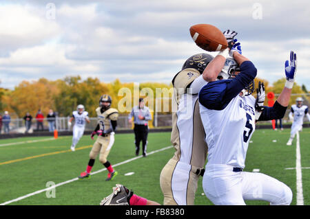 Wide receiver e defensive back battaglia per il possesso di un pass durante una scuola di gioco di calcio. Stati Uniti d'America. Foto Stock