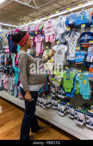 Donna incinta guardando vestiti del bambino Walmart Store, Pasco, nello Stato di Washington, USA Foto Stock