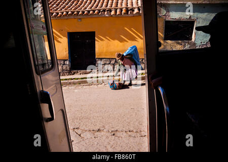 Una cholita raccoglie le sue cose per un mini-bus ride in Potosi, Bolivia. Foto Stock