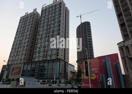 Cluster di applicazioni residenziali e commerciali highrises essendo costruito in una piccola città tipica in Cina. Foto Stock