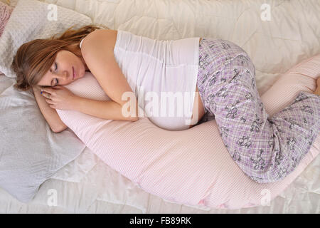 Donna incinta dorme tranquillamente in camera da letto Foto Stock