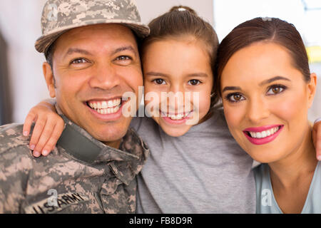 Felice famiglia militare di tre rilassanti insieme a casa Foto Stock