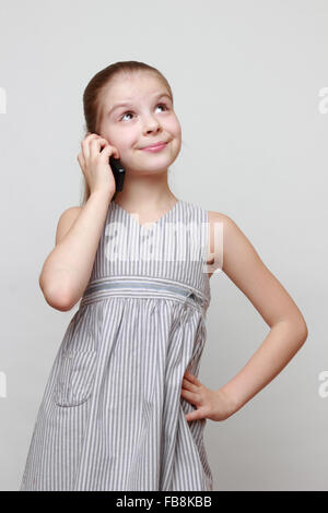 Bella caucasian bambina chiamata sul telefono cellulare Foto Stock