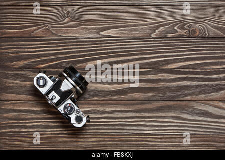 Retrò fotocamera reflex sul vecchio sfondo di legno vista superiore Foto Stock