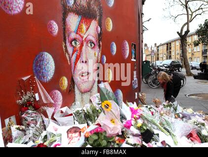 Londra, Gran Bretagna. Xii gen, 2016. Un ventilatore presenta fiori a David Bowie murale di Brixton, Sud Londra, Gran Bretagna, a gennaio 12, 2016. Credito: Han Yan/Xinhua/Alamy Live News Foto Stock