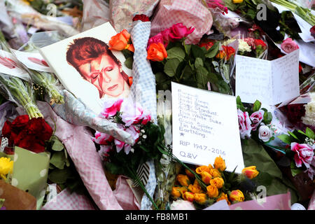 Londra, Gran Bretagna. Xii gen, 2016. I fiori e i messaggi sono visti a David Bowie murale di Brixton, Sud Londra, Gran Bretagna, a gennaio 12, 2016. Credito: Han Yan/Xinhua/Alamy Live News Foto Stock