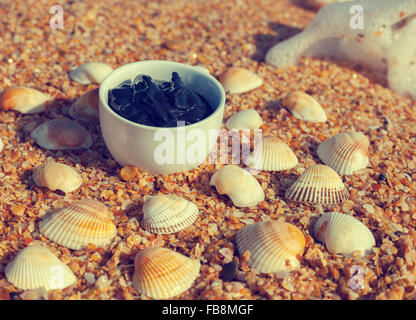 Fango del Mar Morto in una tazza in riva al mare Foto Stock