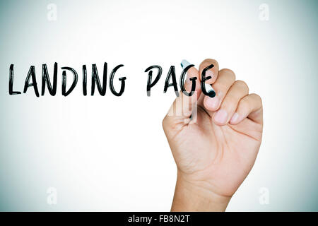 Primo piano della mano di un giovane uomo caucasico della scrittura del testo landing page in primo piano Foto Stock