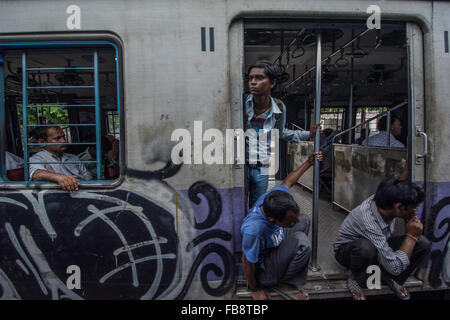 Passeggeri guardando fuori della porta su un treno indiano. Foto Stock