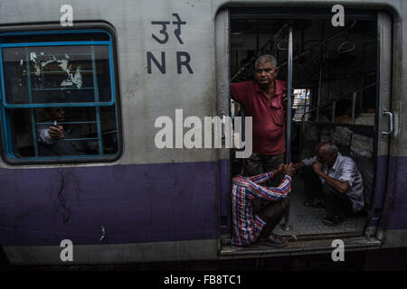 Passeggeri guardando fuori della porta su un treno indiano. Foto Stock