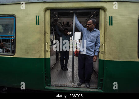 Passeggeri guardando fuori della porta su un treno indiano. Foto Stock