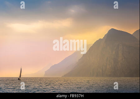 Bellissima vista di uno yacht a vela montagne passato sul Lago di Garda, Italia. Foto Stock