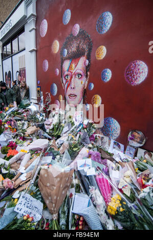 Londra, Regno Unito. Il 12 gennaio 2016. Ventole continuano a visitare il murale di David Bowie a Brixton per pagare i loro rispetti e lasciare i tributi seguenti notizie che l'iconica 69 anno vecchio cantante era morto di cancro il giorno precedente. Credito: Stephen Chung / Alamy Live News Foto Stock