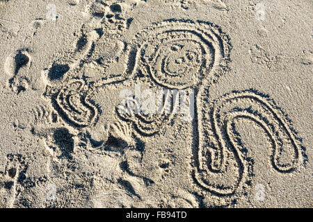 Bambino del disegno della faccia felice polpo con lunghi tentacoli in sabbia a Playa Las Conchas Puerto Penasco Foto Stock