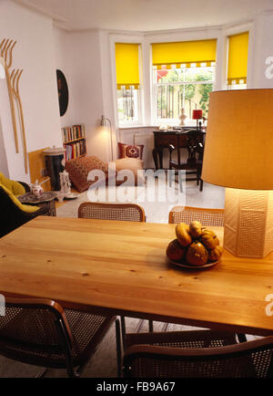 La Lampada sul tavolo di pino in zona pranzo degli anni sessanta soggiorno con persiane di colore giallo su windows Foto Stock