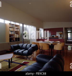 Oltre farcite divani di pelle nera in un piano aperto degli anni novanta un soggiorno e sala da pranzo Foto Stock