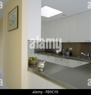 Anni Trenta chrome teiera sul piano di lavoro in acciaio inox in cucina bianca Foto Stock