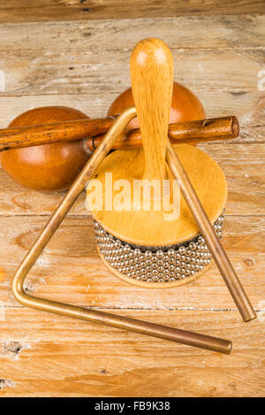 Tradizionale piccola p'ercussion strumenti in una vita ancora su un rustico di una superficie di legno Foto Stock