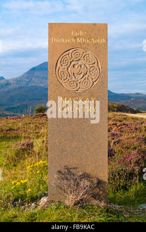 Costa Nord 500 - monumento di pietra con il gaelico iscrizione ingresso marcatura di Mackay paese, vicino a Kylesku, Sutherland, Quinag in vista dietro. Foto Stock