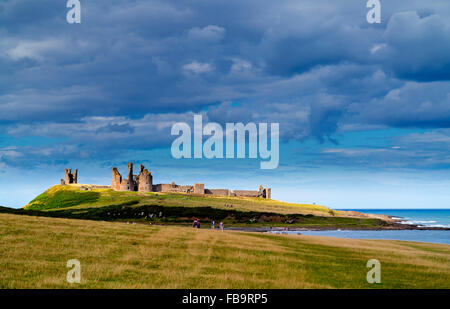 Rovine del Castello di Dunstanburgh in Northumberland North East England Regno Unito con Embleton Bay e il mare del Nord visibile oltre Foto Stock