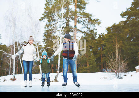 Famiglia pattinaggio sul ghiaccio nel parco Foto Stock