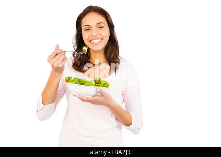 Bella donna sorridente mangiare insalata Foto Stock