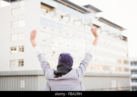 Donna felice alzando le mani in alto Foto Stock