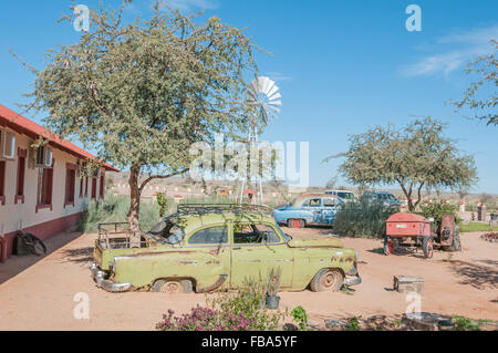 Il Fish River Canyon, NAMIBIA - Giugno 17, 2011: vecchie automobili arrugginite e un trattore usato come un display in un giardino in un lodge vicino al fi Foto Stock