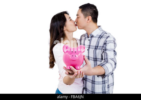 Giovane kissing tenendo salvadanaio Foto Stock