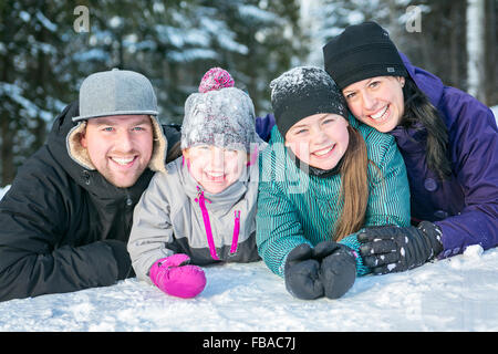 Felici i genitori e i loro bambini in winterwear Foto Stock