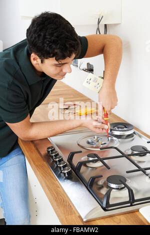 Workman Installazione di fornello a gas in cucina nuova Foto Stock