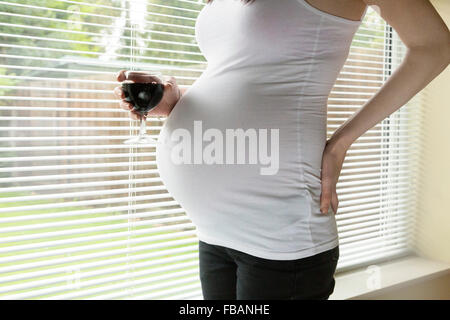 Donna incinta bere alcool / vino rosso Foto Stock