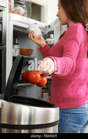 Donna gettando via fuori della data di alimenti in frigorifero Foto Stock