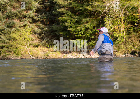 Maschio di pescatore di Pesca a Mosca Report di Pesca in un fiume sulla Penisola Olimpica nello Stato di Washington Foto Stock