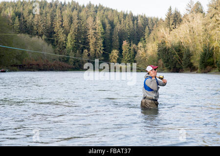 Maschio di pescatore di Pesca a Mosca Report di Pesca in un fiume sulla Penisola Olimpica nello Stato di Washington Foto Stock